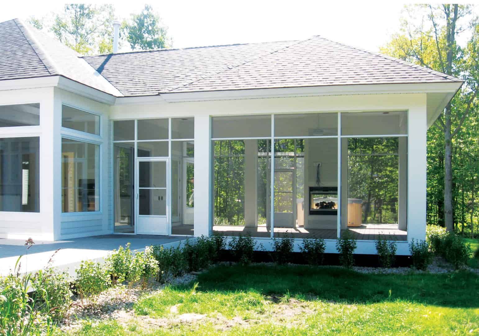 A house with a screened in porch and a fireplace