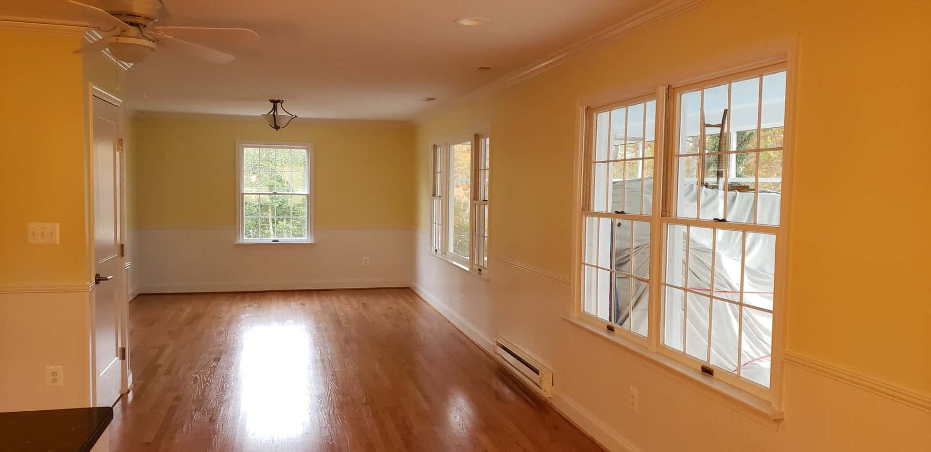 An empty living room with hardwood floors and a ceiling fan.