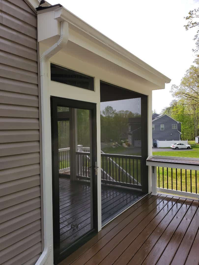 A screened in porch with a sliding glass door