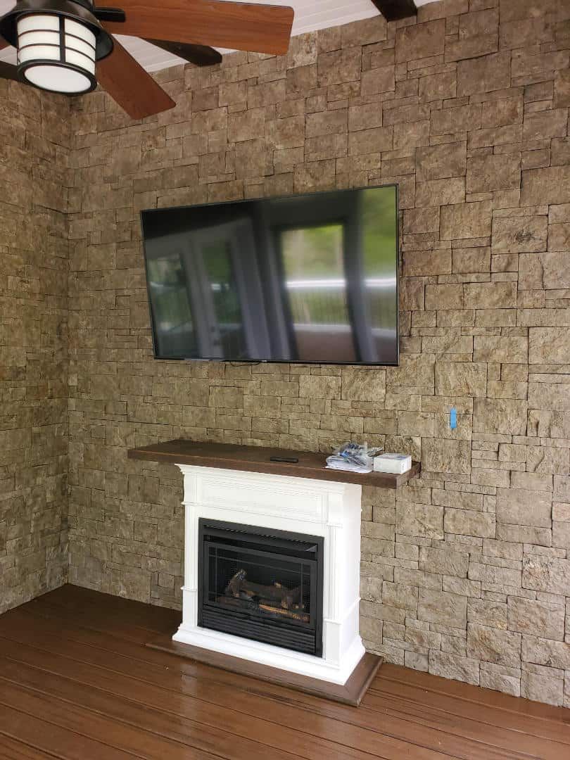 A living room with a fireplace and a flat screen tv on the wall.