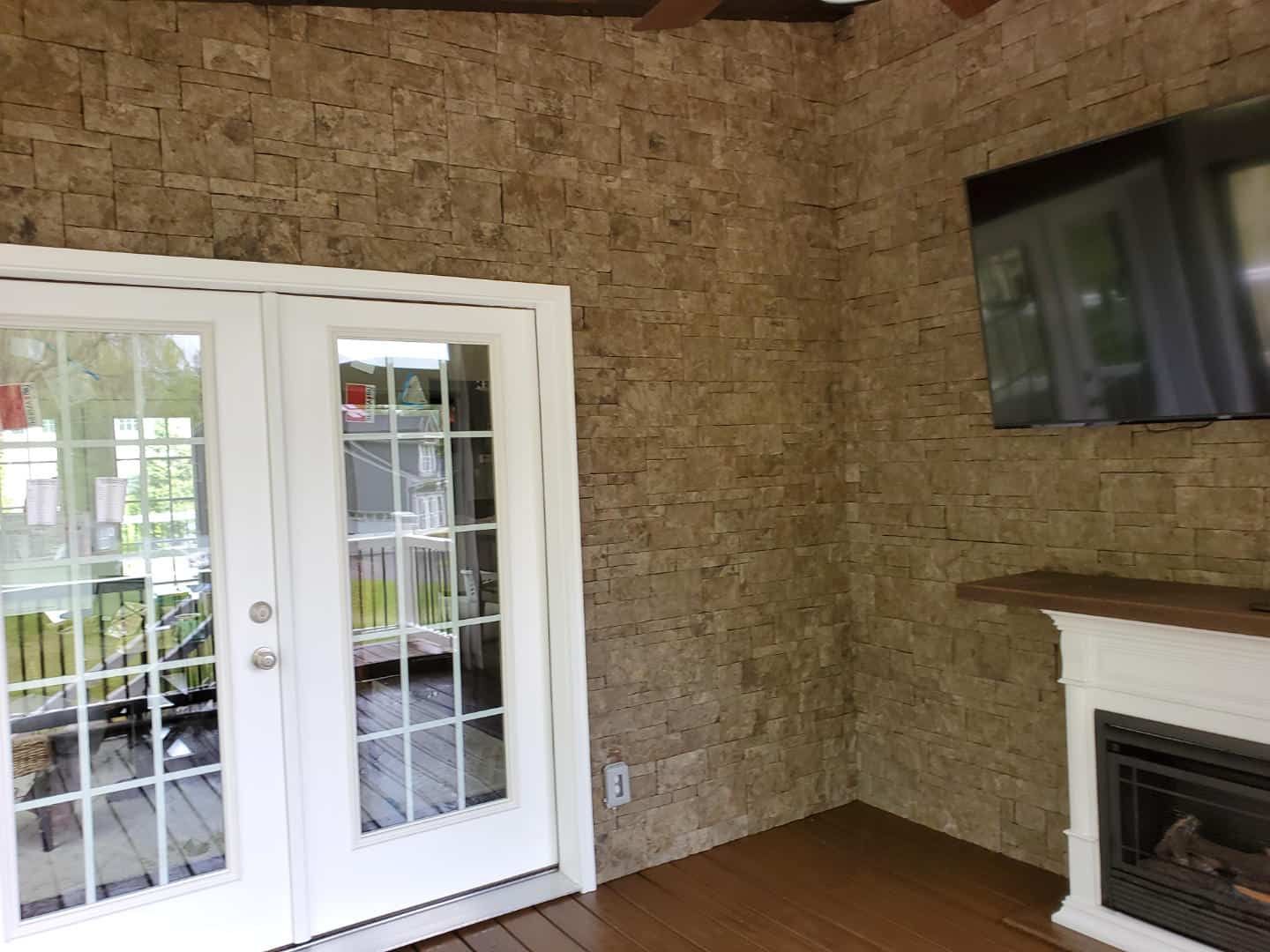A living room with a fireplace and a television on the wall.