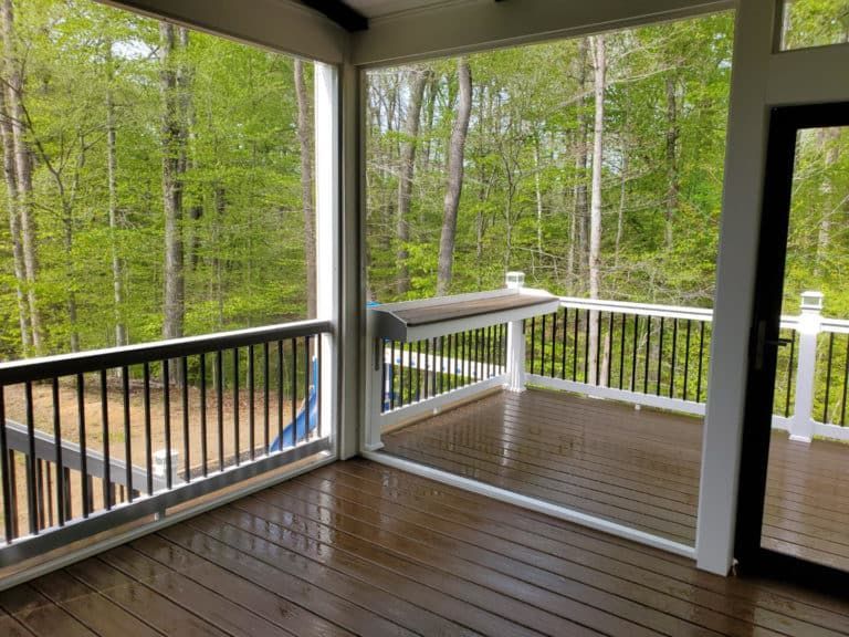 There is a screened in porch with a view of the woods.