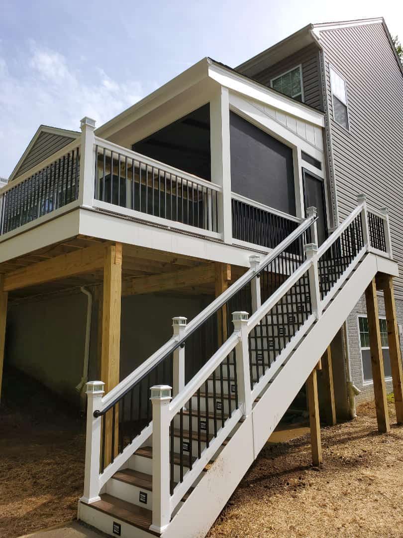 A house with a screened in porch and stairs leading up to it