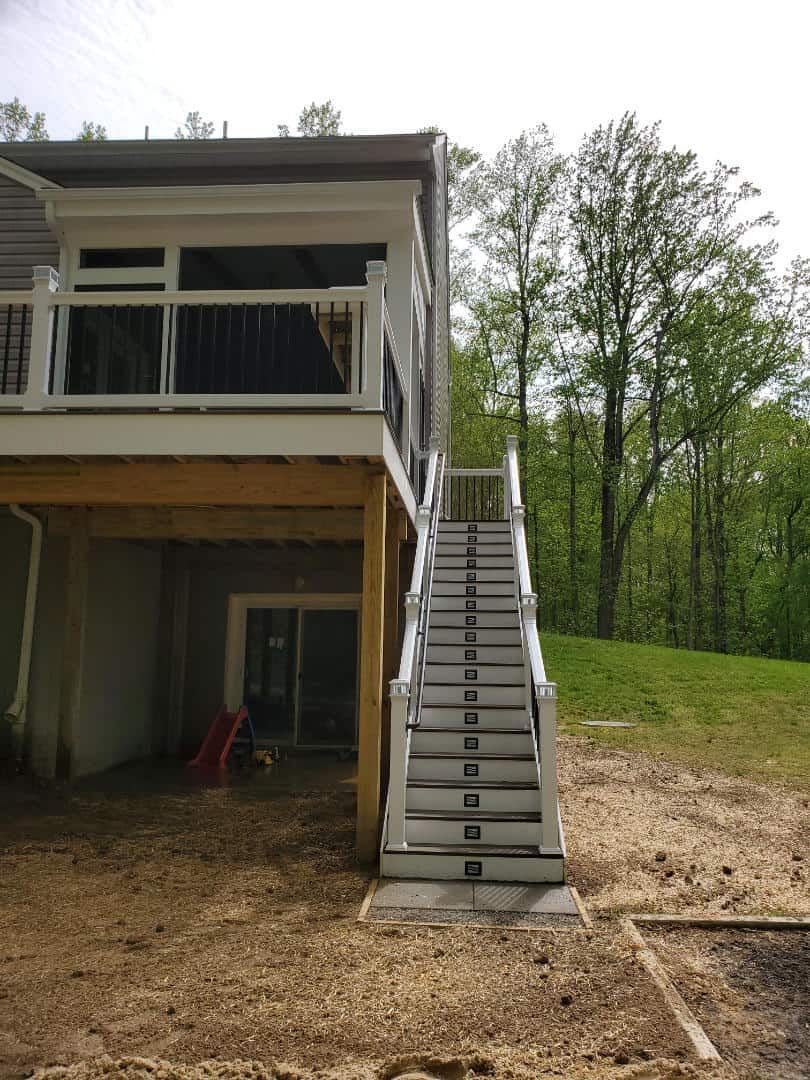A house with a deck and stairs leading up to it.