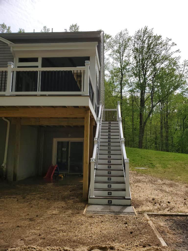 A house with a deck and stairs leading up to it.