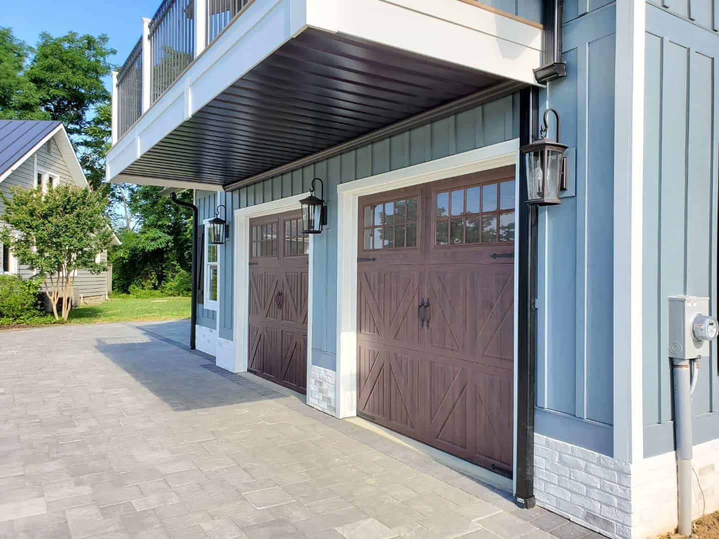 There are two garage doors on the side of a house.
