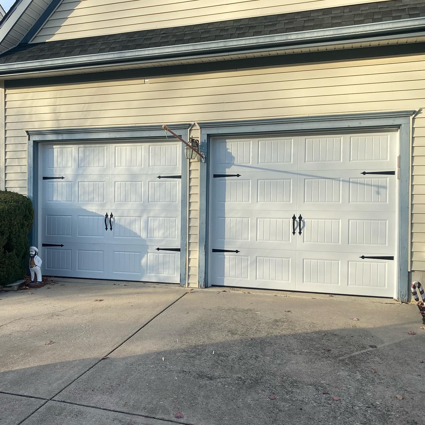 2 white garage doors showcase black hardware on doors