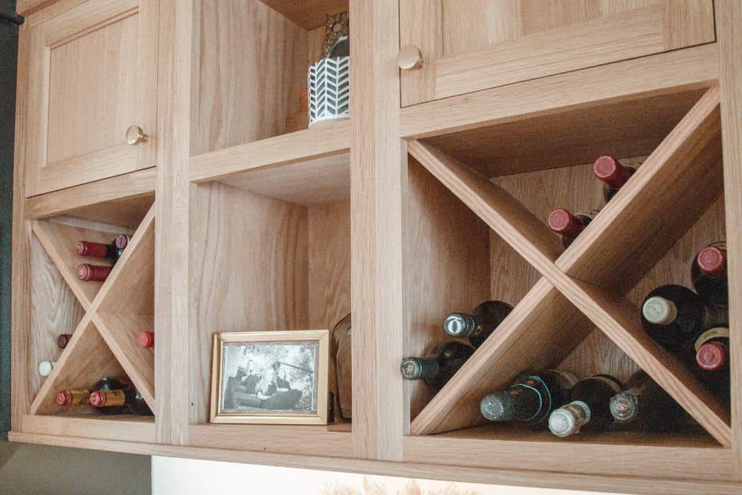 A wooden wine rack with bottles of wine in it.