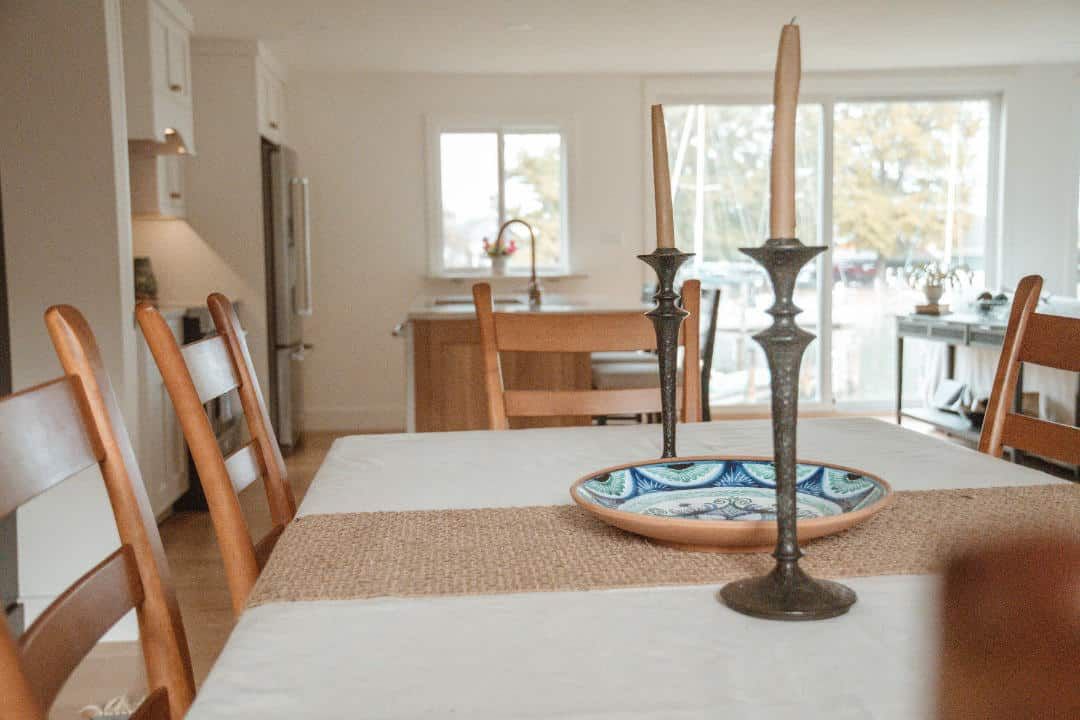 A dining room table with candles and a plate on it.