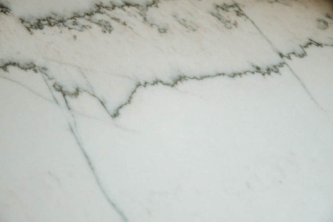 A close up of a white marble counter top with black veins.