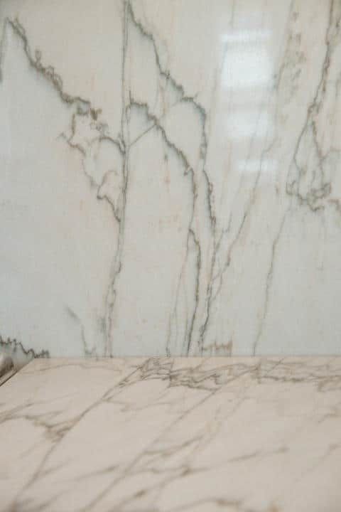 A marble counter top with a marble wall in the background.