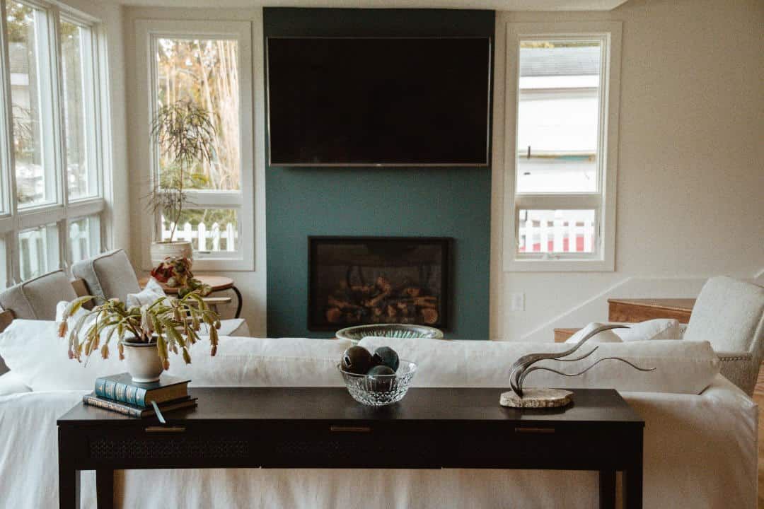 A living room with a fireplace , couch , table and television.
