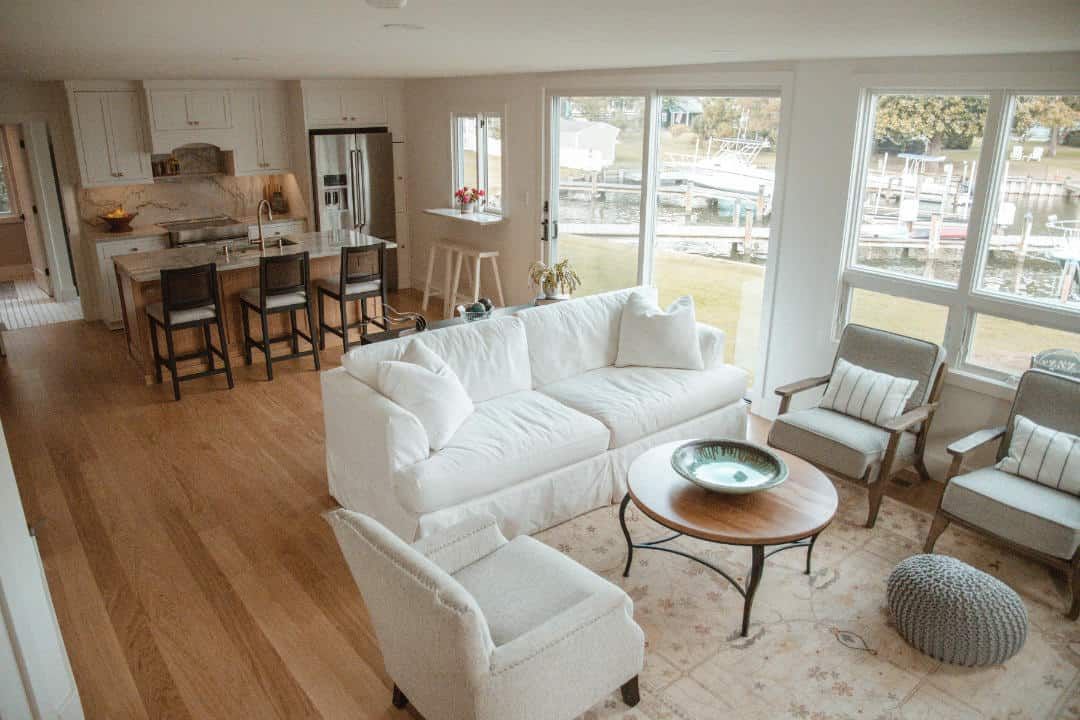 A living room with a white couch , chairs , and a coffee table.