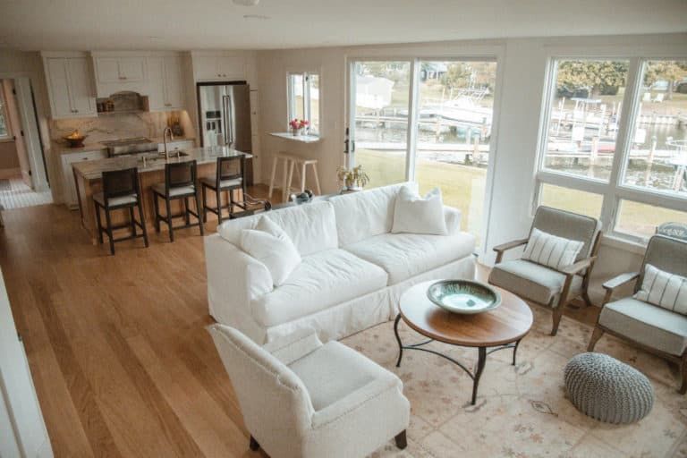 A living room with a couch , chairs , and a coffee table.