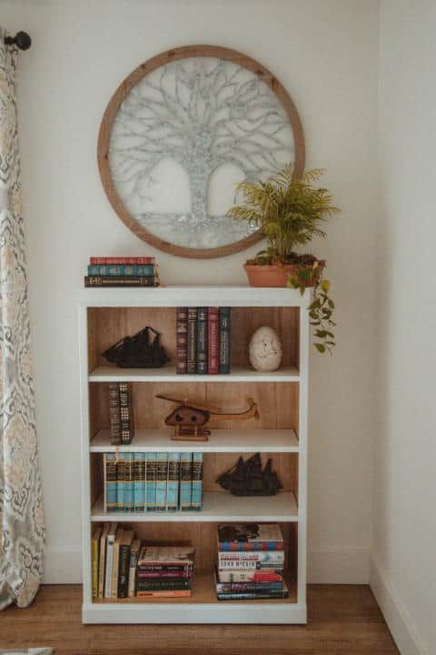 A bookshelf filled with books and a picture on the wall.