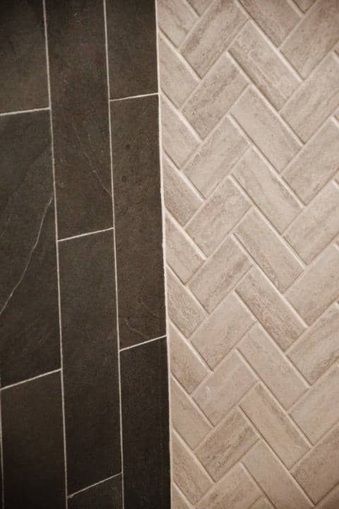 A close up of a tile floor with a herringbone pattern.