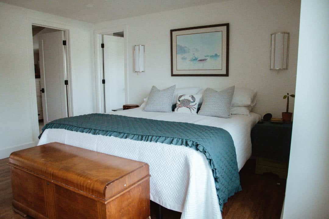 A bedroom with a bed and a wooden bench.