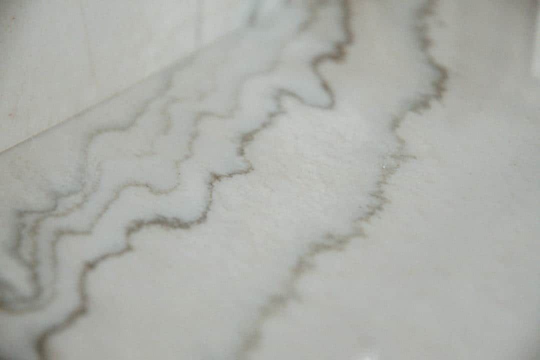 A close up of a white marble counter top with a swirl pattern.