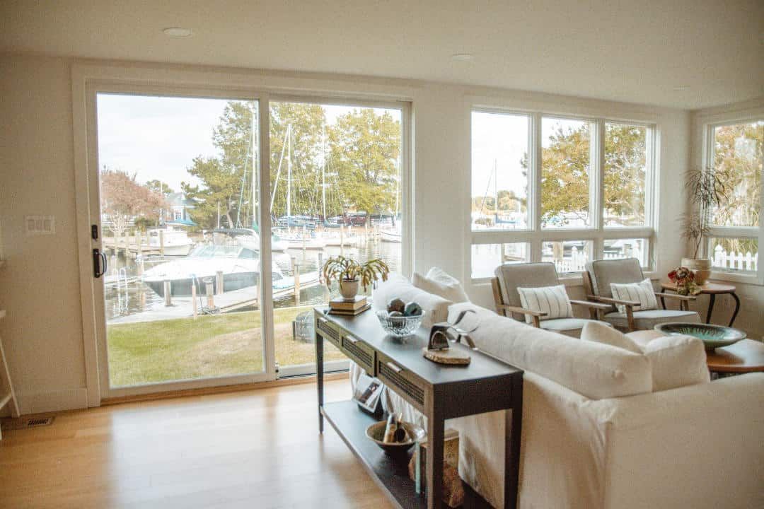 A living room with a couch , chairs , table and sliding glass doors.