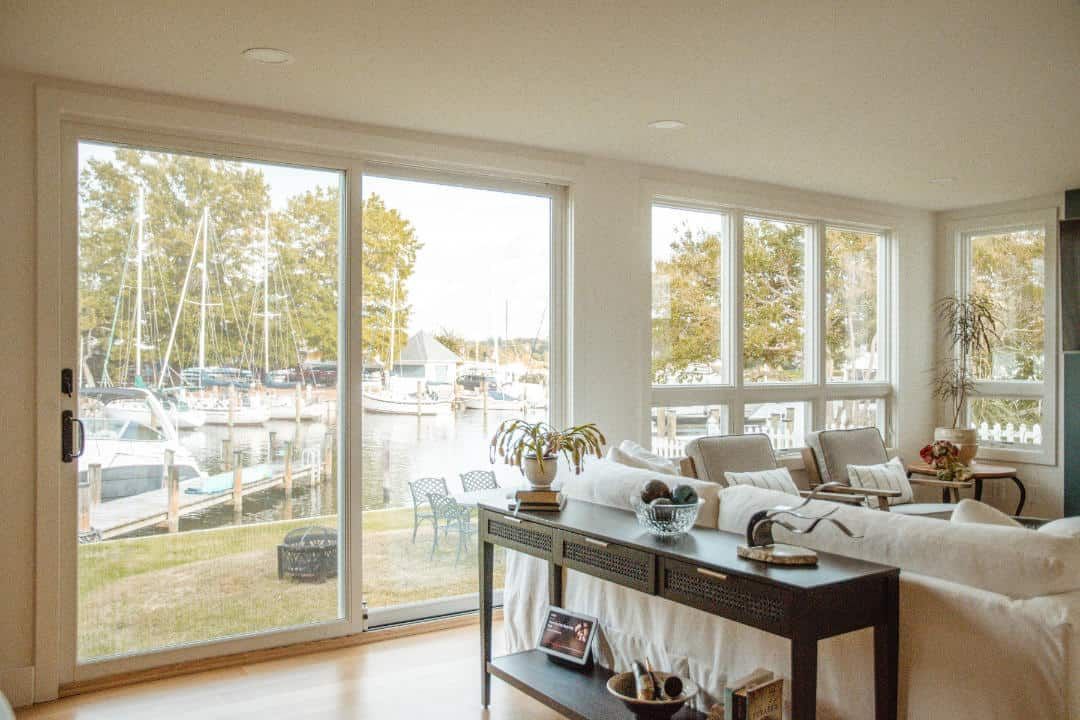A living room with a couch , table , chairs and sliding glass doors.