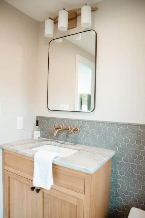 A bathroom with a sink , mirror and toilet.