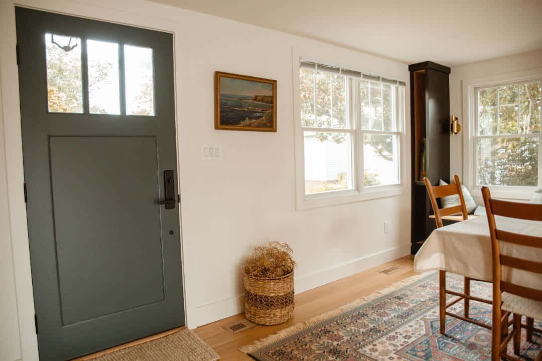 A living room with a table and chairs and a door.