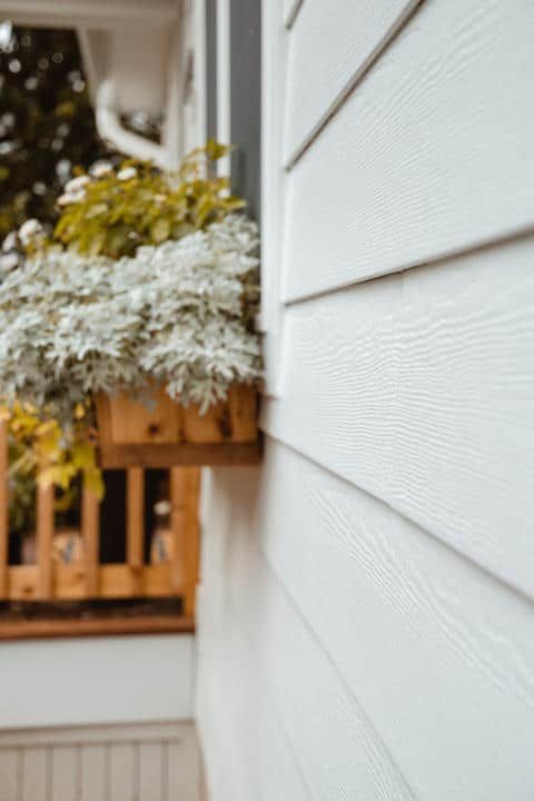 A white house with a planter on the side of it.