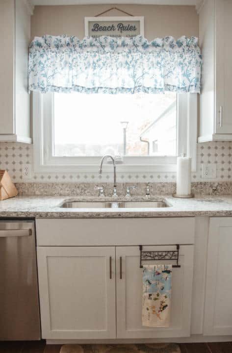 A kitchen with a sink , dishwasher , and window.