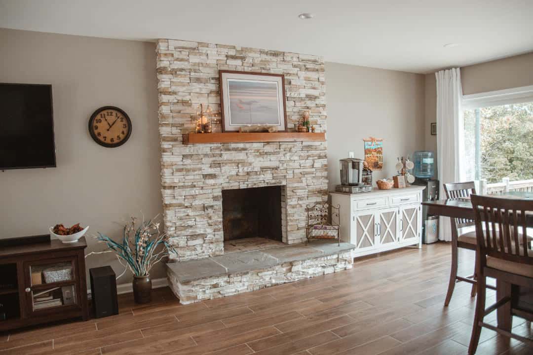 A living room with a fireplace and a clock on the wall.