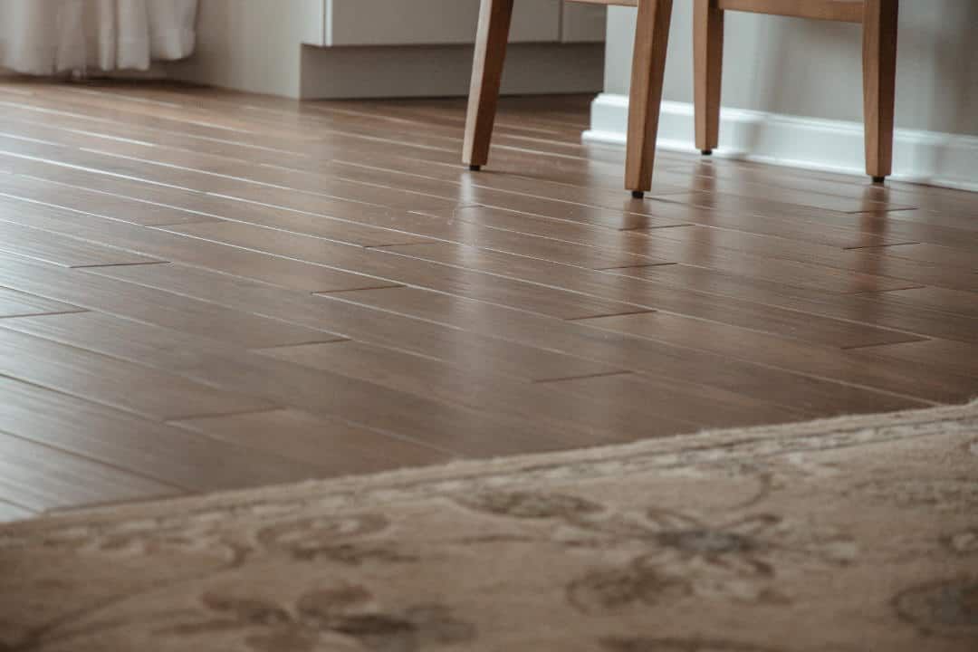 A chair is sitting on a wooden floor next to a rug.