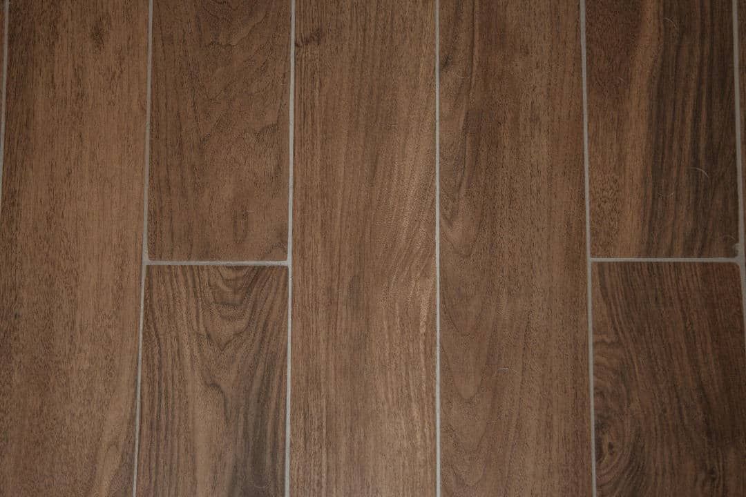 A close up of a wooden floor with a white border.