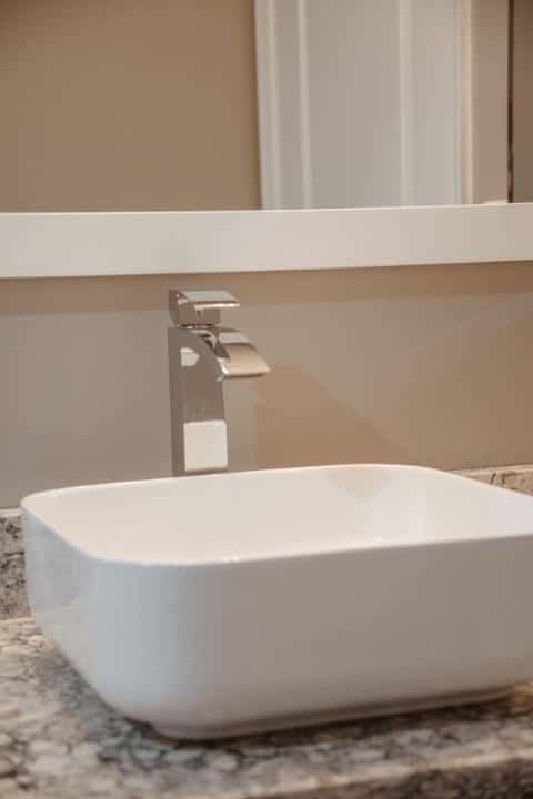 A bathroom sink with a faucet and a mirror.