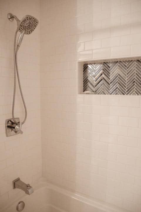 A shower head is sitting next to a bathtub in a bathroom.