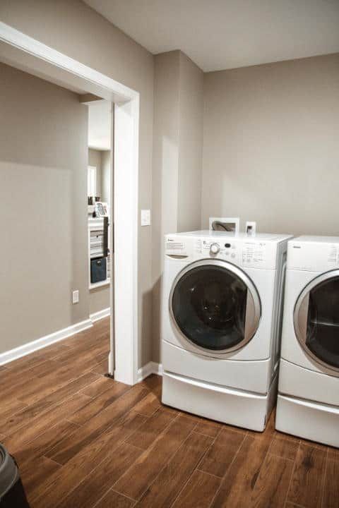 A laundry room with two white washers and dryers.