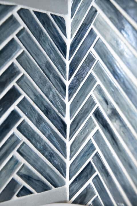 A close up of a blue and white tile with a herringbone pattern.