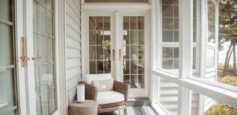 A screened in porch with a chair and a table.