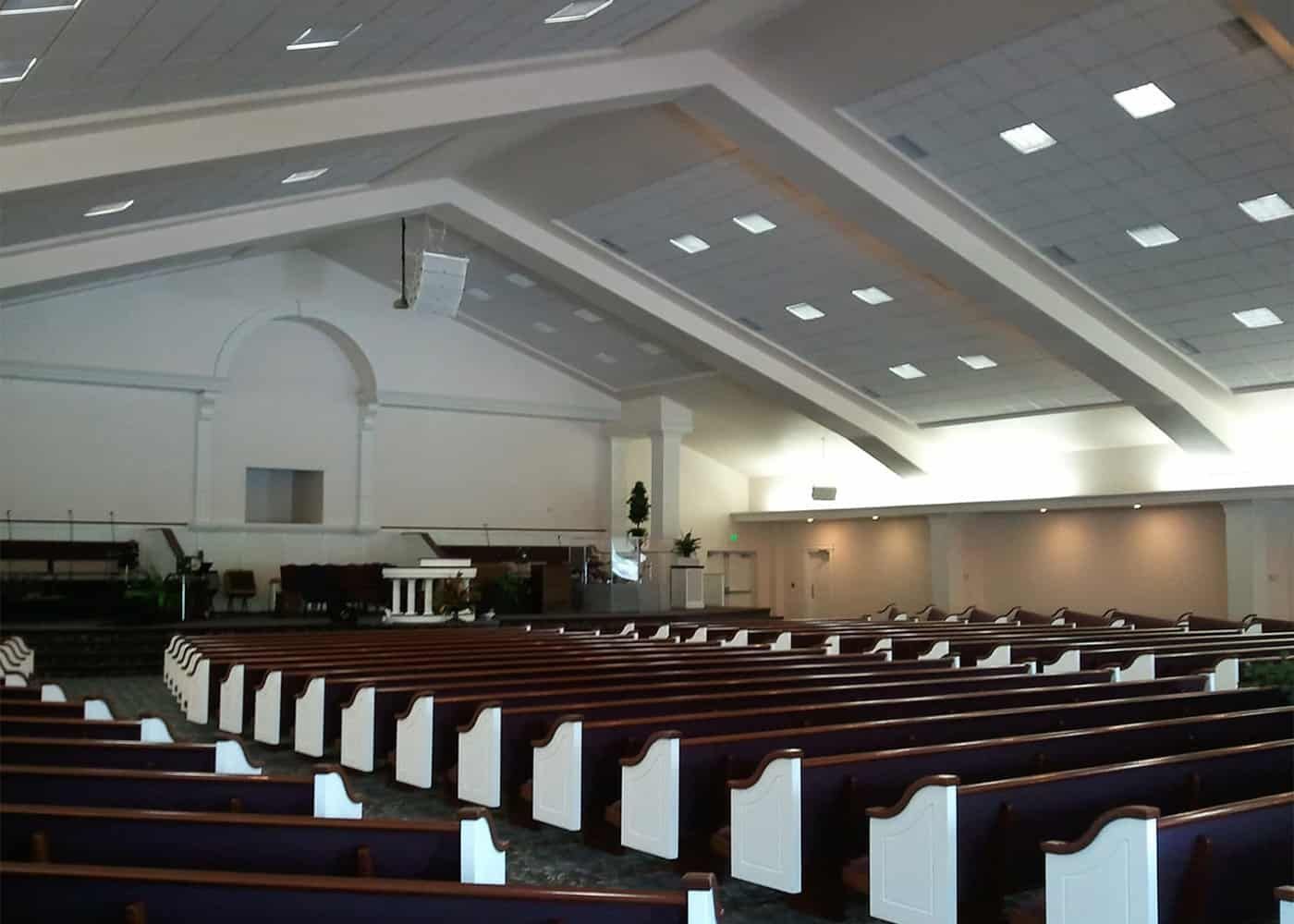 An empty church with rows of purple and white benches