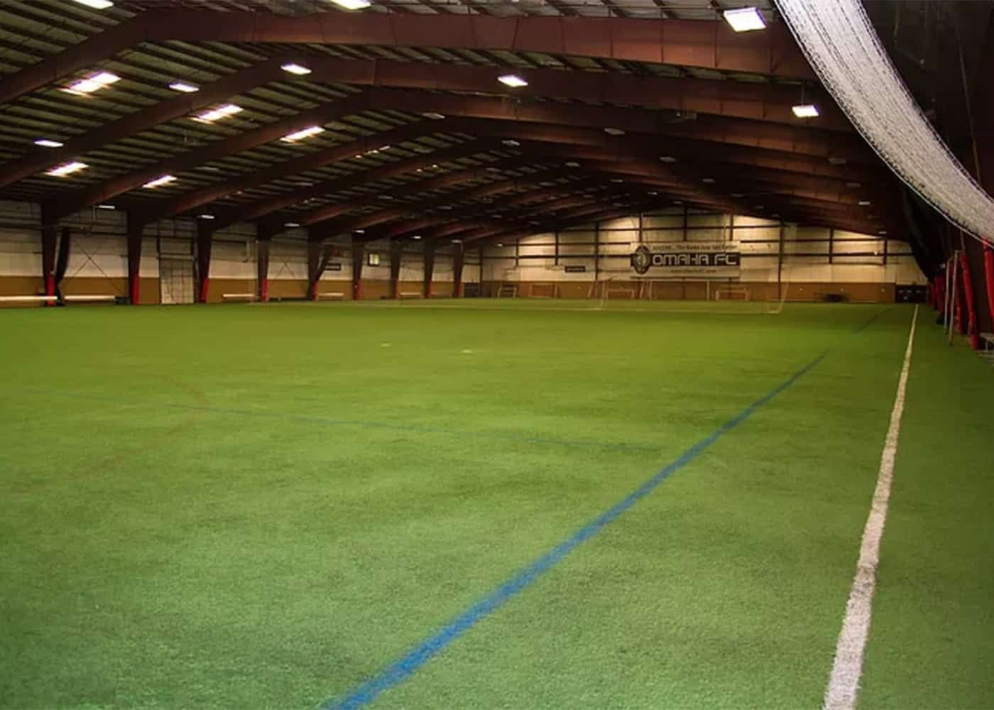 A large indoor soccer field with a blue line