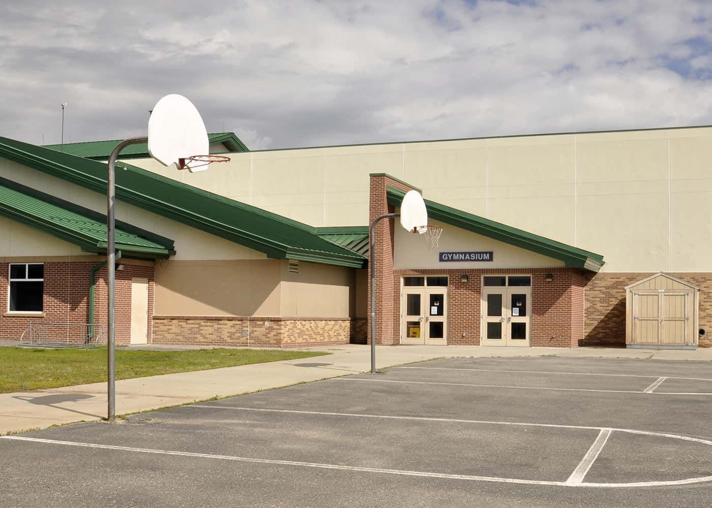 A basketball court in front of a building that says ' willow ' on it