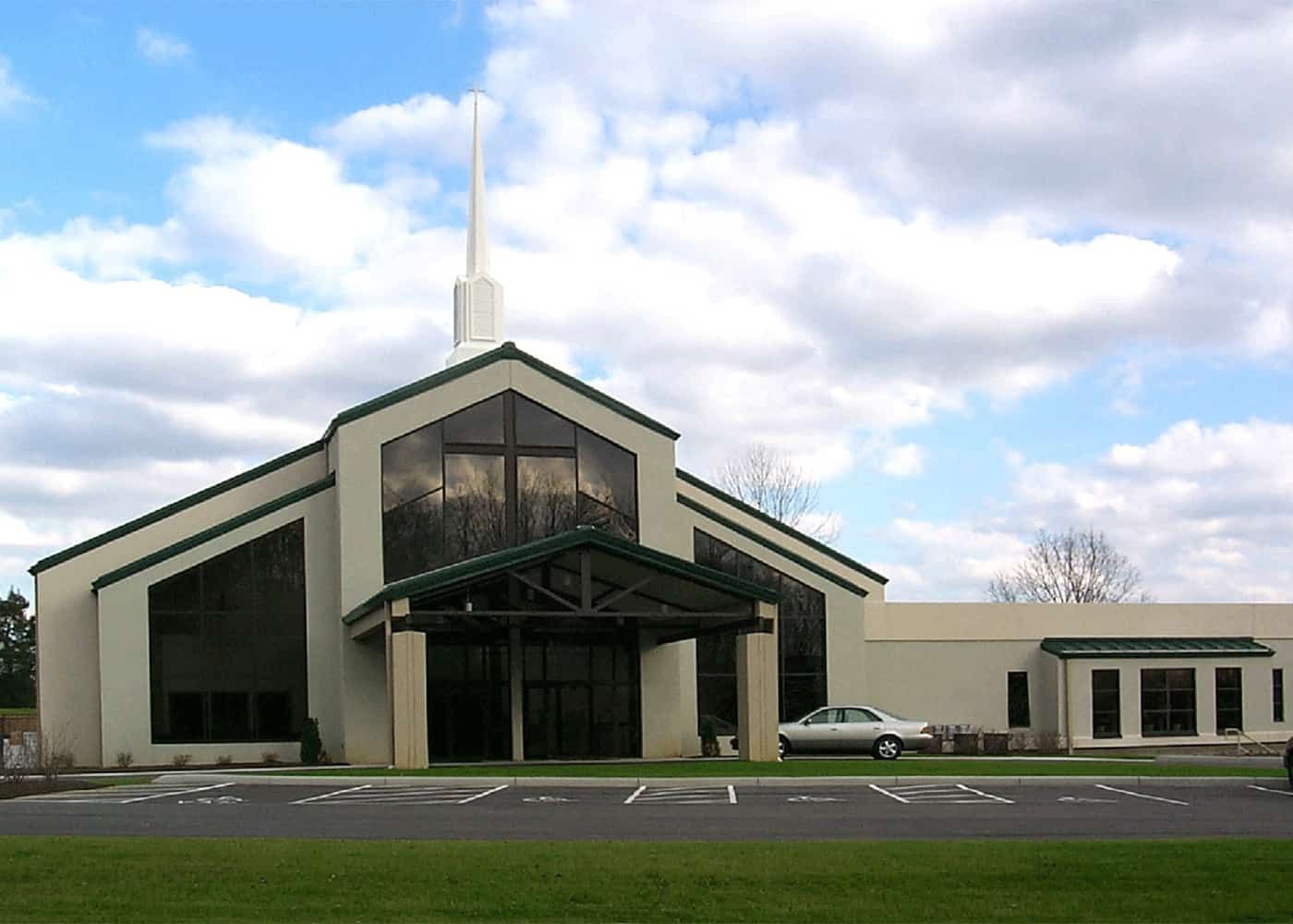 A church with a white car parked in front of it