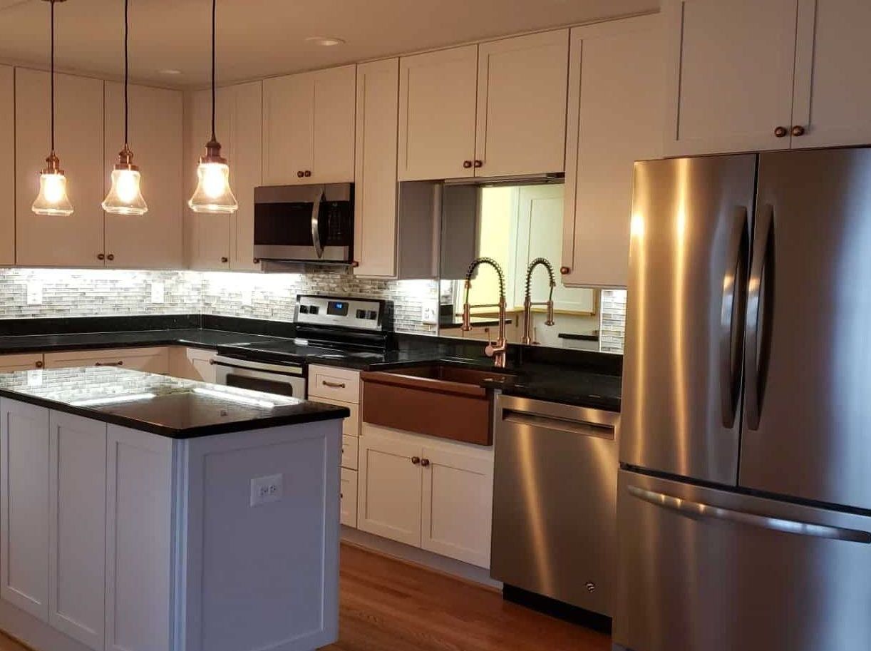 A kitchen with stainless steel appliances and white cabinets