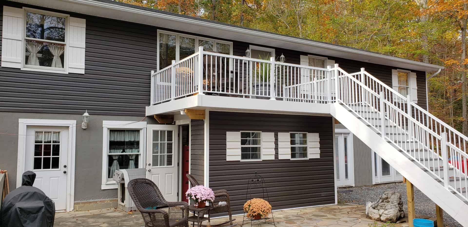 A large house with a large deck and stairs leading up to it.