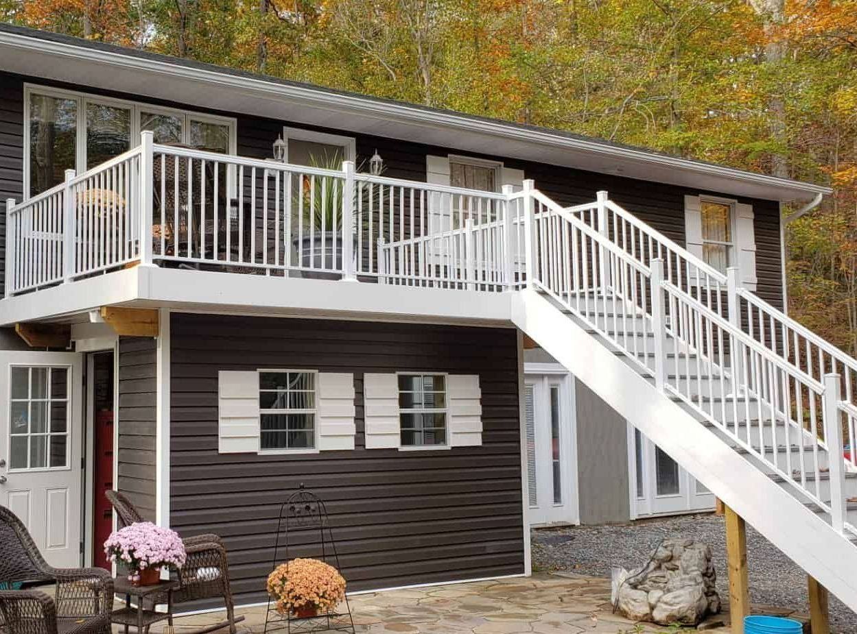 A house with a balcony and stairs leading up to it.