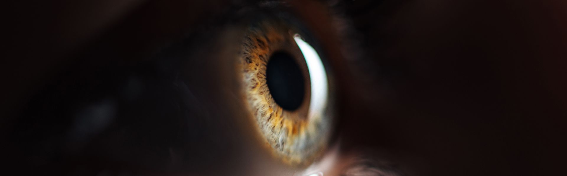 A close up of a person 's eye in the dark.