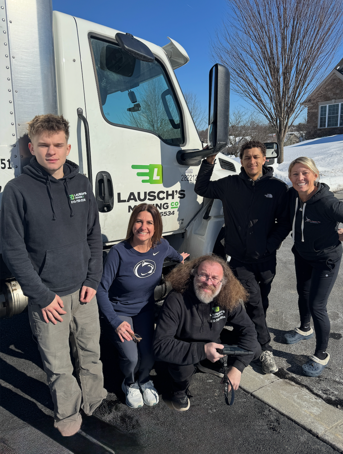 Man holds keys, smiling at woman; boxes and shelves in the background. They are inside, likely moving.