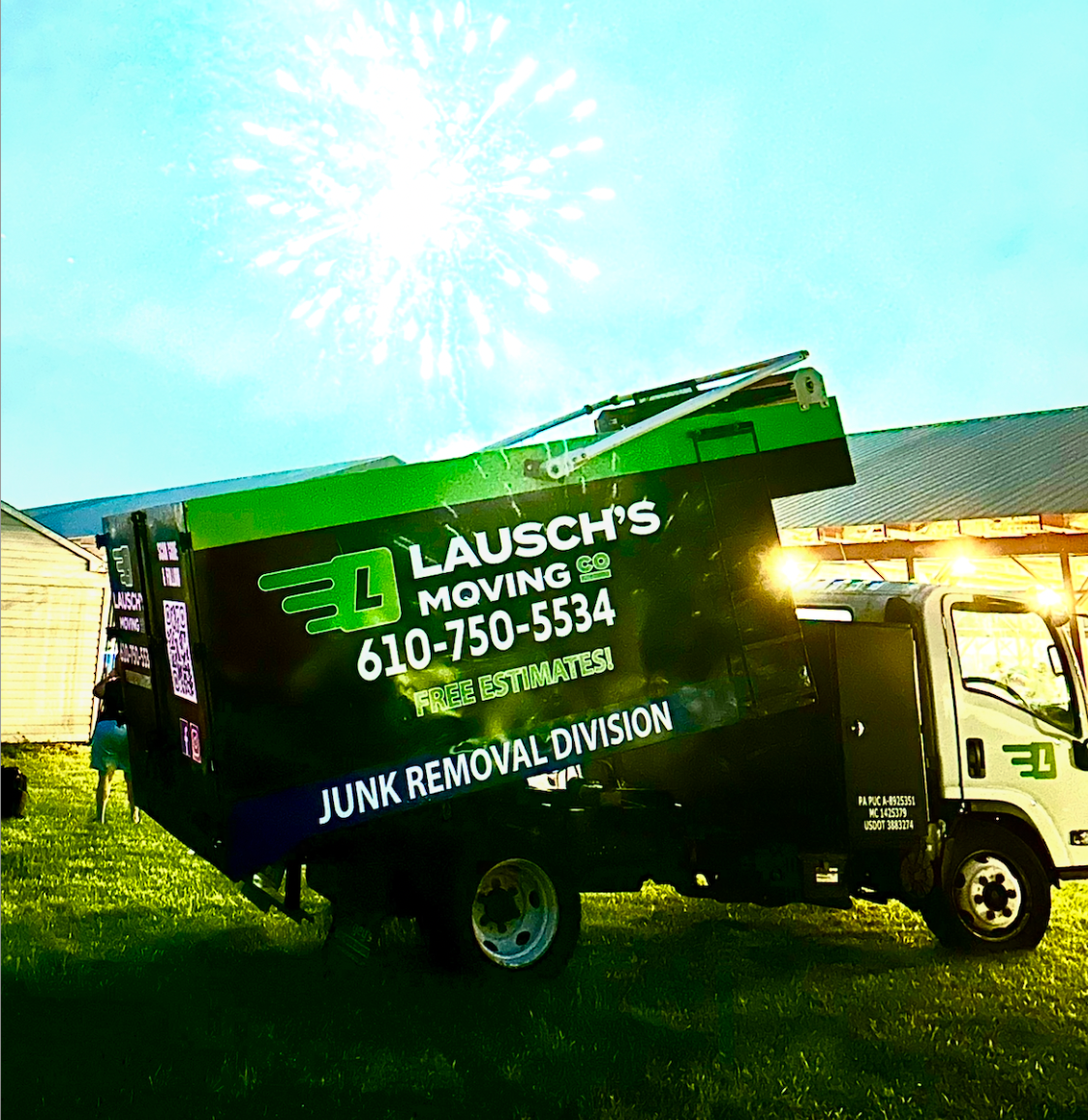 Movers in blue uniforms loading cardboard boxes into a truck, outdoors.