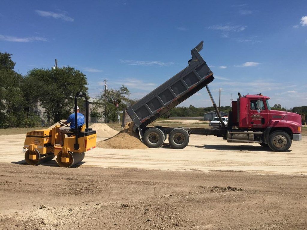 a yellow bulldozer is driving through a dirt field