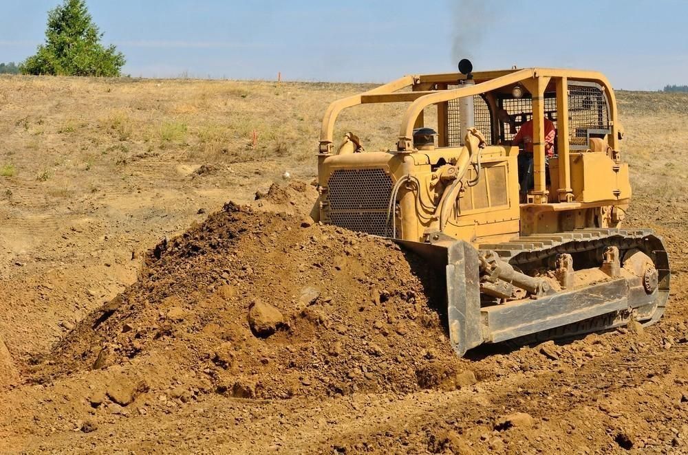 Yellow bulldozer pushing dirt on a construction site.