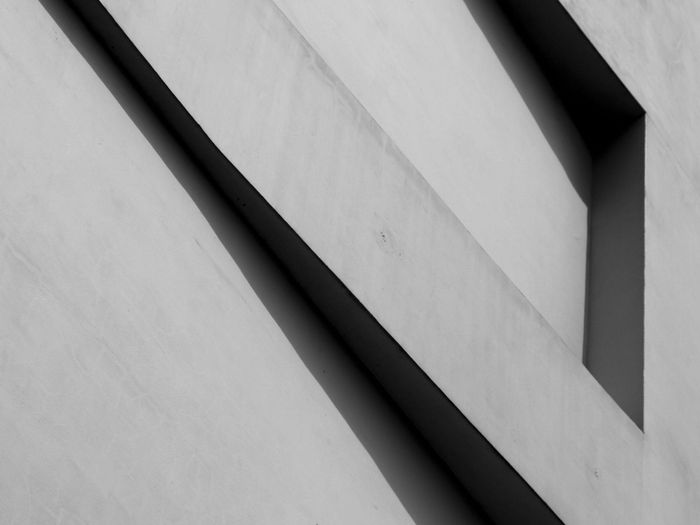 Geometrische Linien und Schatten auf einer grauen Betonoberfläche.