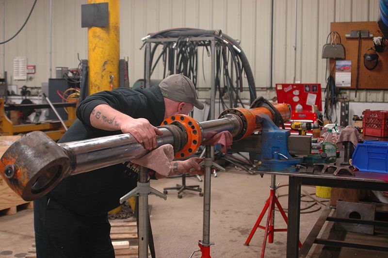 A man is welding a piece of metal in a factory.